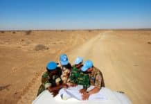 Visite du camp de Smara. Des casques bleus de l'ONU originaires du Ghana, de France, du Bangladesh et de Mongolie consultent une carte pour s'orienter dans la vaste zone de Smara. Crédits photo : Martine Perret/ONU.