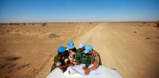 L’équilibre entre standardisation et adaptations des opérations de paix – Comment éviter la surcharge des mandats ? Visite du camp de Smara. Des casques bleus de l'ONU originaires du Ghana, de France, du Bangladesh et de Mongolie consultent une carte pour s'orienter dans la vaste zone de Smara. Crédits photo : Martine Perret/ONU.