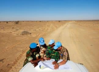 Visite du camp de Smara. Des casques bleus de l'ONU originaires du Ghana, de France, du Bangladesh et de Mongolie consultent une carte pour s'orienter dans la vaste zone de Smara. Crédits photo : Martine Perret/ONU.