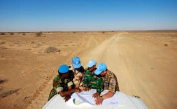 L’équilibre entre standardisation et adaptations des opérations de paix – Comment éviter la surcharge des mandats ? Visite du camp de Smara. Des casques bleus de l'ONU originaires du Ghana, de France, du Bangladesh et de Mongolie consultent une carte pour s'orienter dans la vaste zone de Smara. Crédits photo : Martine Perret/ONU.