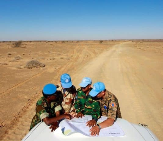 L’équilibre entre standardisation et adaptations des opérations de paix – Comment éviter la surcharge des mandats ? Visite du camp de Smara. Des casques bleus de l'ONU originaires du Ghana, de France, du Bangladesh et de Mongolie consultent une carte pour s'orienter dans la vaste zone de Smara. Crédits photo : Martine Perret/ONU.